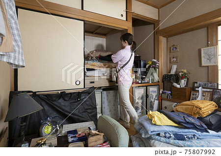 散らかった部屋を片付ける女性作業員 散らかった部屋を片付ける女性作業員 75807992