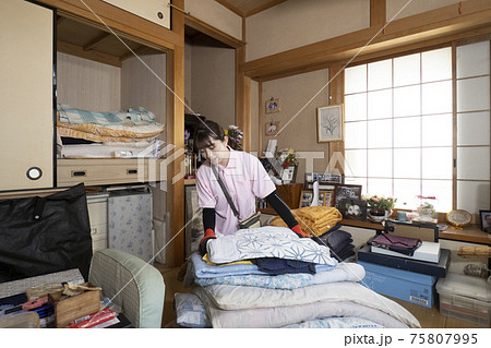 散らかった部屋を片付ける女性作業員 散らかった部屋を片付ける女性作業員 75807995