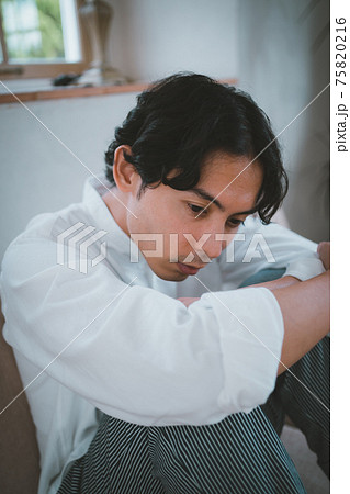 膝を抱える男性 75820216