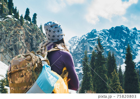 Traveling girl with backpack hiking in the mountains, freedom concept. Hiking people on Asia. Beautiful young woman traveler with a backpack looks at the mountain top before climbing Traveling girl with backpack hiking in the mountains, freedom concept. Hiking people on Asia. Beautiful young woman traveler with a backpack looks at the mountain top before climbing 75820803
