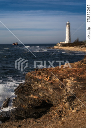 Lone beacon guards the ships. The lighthouse shows the way for boats. Wrecked ship lays nearby Lone beacon guards the ships. The lighthouse shows the way for boats. Wrecked ship lays nearby 75822262