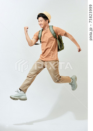 young man with backpack celebrating in mid air, movement jumping isolated in studio young man with backpack celebrating in mid air, movement jumping isolated in studio 75823999