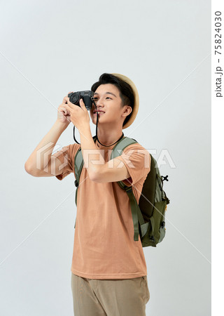 Young cheerful man photographer takes images with digital camera Young cheerful man photographer takes images with digital camera 75824030
