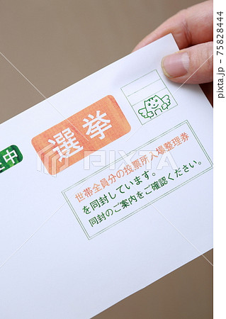 選挙の封筒を持つシニアの手 75828444