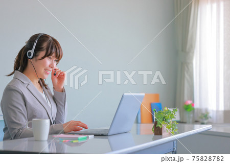 オンラインミーティング_ヘッドセットを手を添える女性 オンラインミーティング_ヘッドセットを手を添える女性 75828782