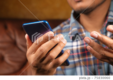 Close up of young man hand using smart phone. 75830060