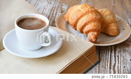 Cup of coffee and croissant on a wooden table 75830263
