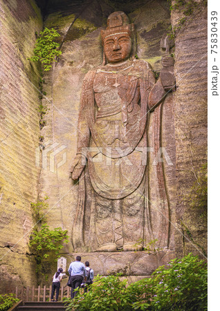 [千葉・鋸山] 鋸山の石切り場跡の断面に彫られた百尺観音菩薩の磨崖仏の麓で祈る観光客。 75830439