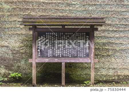 [千葉・鋸山] 鋸山の石切り場跡の壁の前に立つ乾坤山日本寺の説明パネル。 75830444