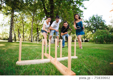 Outdoor games - ring toss, throwing rings outdoors in summer park. 75830602