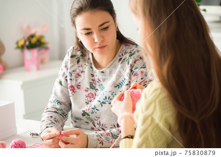 Young attractive girls in a knitting lesson 75830879