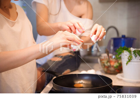 Friends prepearing brekfast and having meal in kitchen together. Friends prepearing brekfast and having meal in kitchen together. 75831039