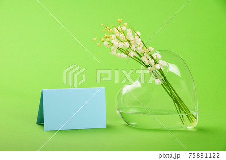 Lilly of the valley in heart shaped vase on green Lilly of the valley in heart shaped vase on green 75831122