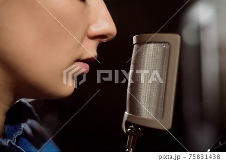 Close up of a singer recording a track in a studio Close up of a singer recording a track in a studio 75831438