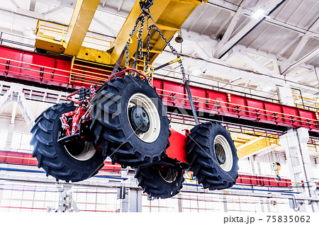 Big tractor wheels installation at assembly room at industrial plant 75835062