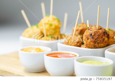 Various mini chicken kievs and sweet potato falafels served with sauces Various mini chicken kievs and sweet potato falafels served with sauces 75835197