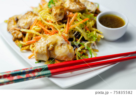 Cooked chicken breast pieces with savory garlic and ginger soy sauce and  noodles, black fungus mushrooms, savoy cabbage, and carrot 75835582