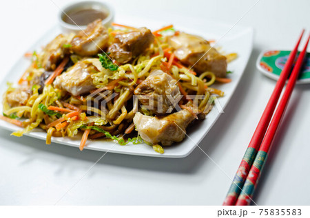 Cooked chicken breast pieces with savory garlic and ginger soy sauce and  noodles, black fungus mushrooms, savoy cabbage, and carrot 75835583