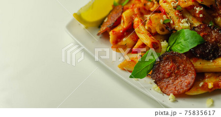 Pennette pasta in a spicy tomato sauce with sliced pepperoni, mozzarella, and mature cheddar cheeses Pennette pasta in a spicy tomato sauce with sliced pepperoni, mozzarella, and mature cheddar cheeses 75835617