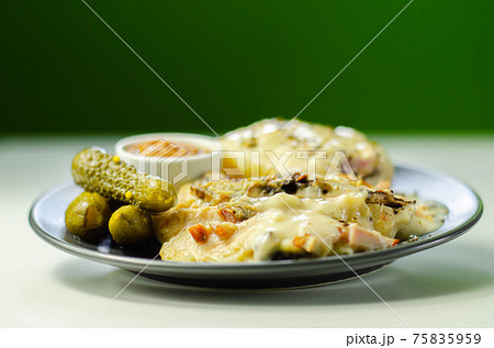 Chicken breast with sliced mushrooms, ham, in cheese sauce with mash potato, pickled red cabbage, and gherkin 75835959