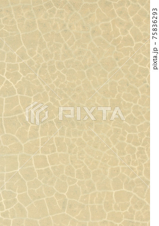 ベージュ 薄黄色 の壁の背景素材 割れ目がデザインされたオシャレな壁 の写真素材