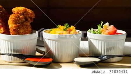 Breaded and herbed chicken breast fillet served with mash potatoes and tomato with onions 75836451