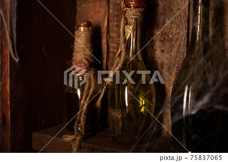 Halloween background Shelves with alchemy tools Skull spiderweb bottle with poison candles Halloween background Shelves with alchemy tools Skull spiderweb bottle with poison candles 75837065