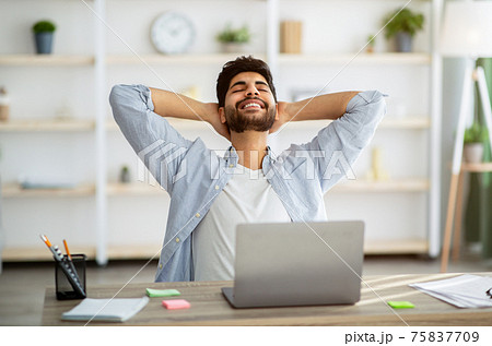Break in work. Relaxed arab man leaning back in chair, resting after work with laptop and holding hands behind head 75837709