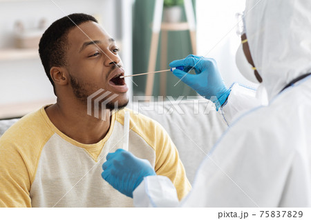 Doc in protective suit takes swab from throat Doc in protective suit takes swab from throat 75837829