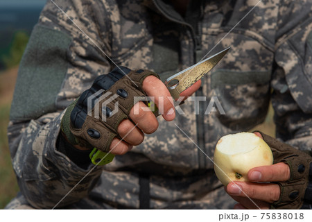 A man with a knife in the forest. 75838018