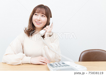 固定電話で話をする笑顔の女性 75838119