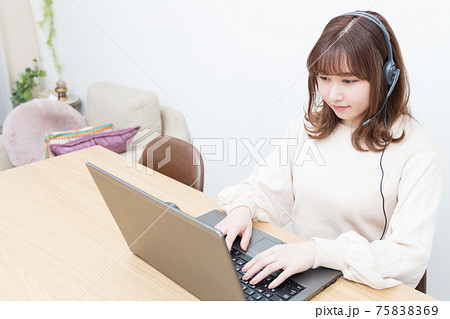 ヘッドセットをつけてPCを使う女性 75838369