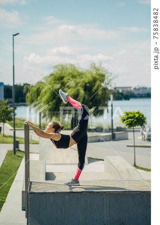 Girl athlete is engaged in yoga on the site by the lake.. 75838482