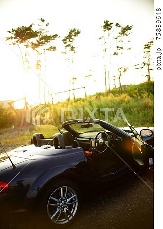 夕暮れ時のオープンカー 75839648