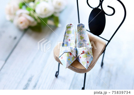 ミニチュアの椅子の上に置かれた折り紙のおしゃれなパンプス 75839734