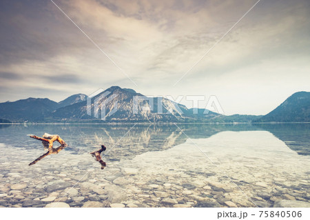 Broken tree branches in water of silent lake in european dolomite Alps. Broken tree branches in water of silent lake in european dolomite Alps. 75840506