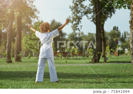 Female child karateka standing on the street Female child karateka standing on the street 75841094