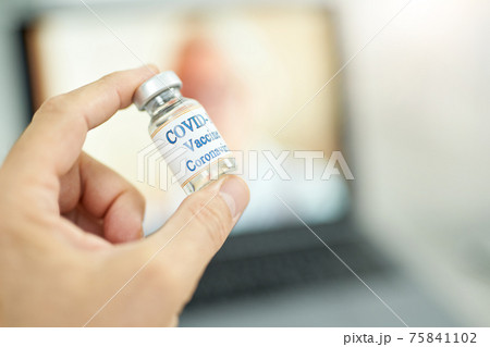 Male hand holding bottle of coronavirus vaccine Male hand holding bottle of coronavirus vaccine 75841102