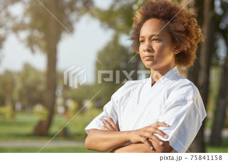 Cute Afro American girl karateka standing on the street Cute Afro American girl karateka standing on the street 75841158