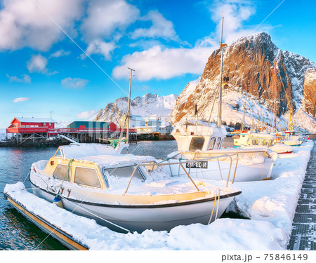 Amazing winter view on Hamnoy village with port and Festhaeltinden mountain on background. Amazing winter view on Hamnoy village with port and Festhaeltinden mountain on background. 75846149