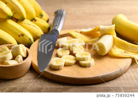Sliced ripe banana fruit on wooden cutting board preparing for cooking 75850244