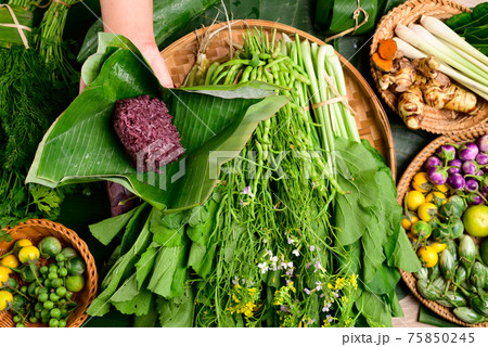 Hand holding purple sticky rice wrapped by banana leaf Hand holding purple sticky rice wrapped by banana leaf 75850245