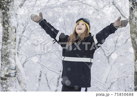 スキー場で降る雪を眺めるスノボ女子 75850688