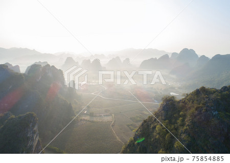 Aerial view of beatiful sunrise over karst mountain peak landscape Aerial view of beatiful sunrise over karst mountain peak landscape 75854885