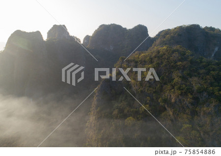 Aerial view of beatiful sunrise over karst mountain peak landscape Aerial view of beatiful sunrise over karst mountain peak landscape 75854886