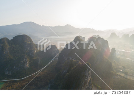 Aerial view of beatiful sunrise over karst mountain peak landscape Aerial view of beatiful sunrise over karst mountain peak landscape 75854887