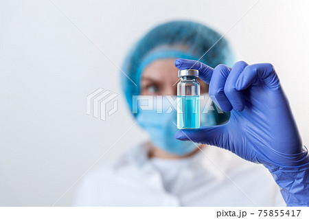 Doctor in gloves and mask holds bottle with vaccine, medicine Doctor in gloves and mask holds bottle with vaccine, medicine 75855417