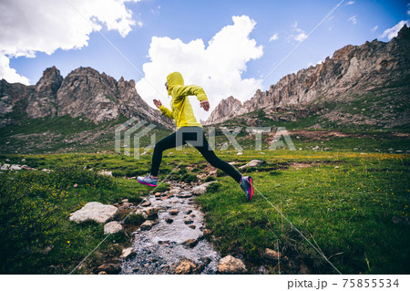 Woman trail runner running in wild mountains Woman trail runner running in wild mountains 75855534