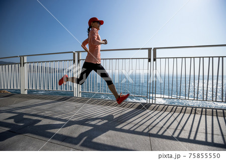 Healthy lifestyle fitness sports woman runner running on seaside trail 75855550