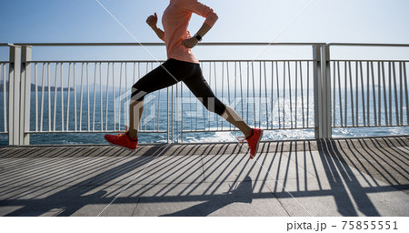 Healthy lifestyle fitness sports woman runner running on seaside trail 75855551